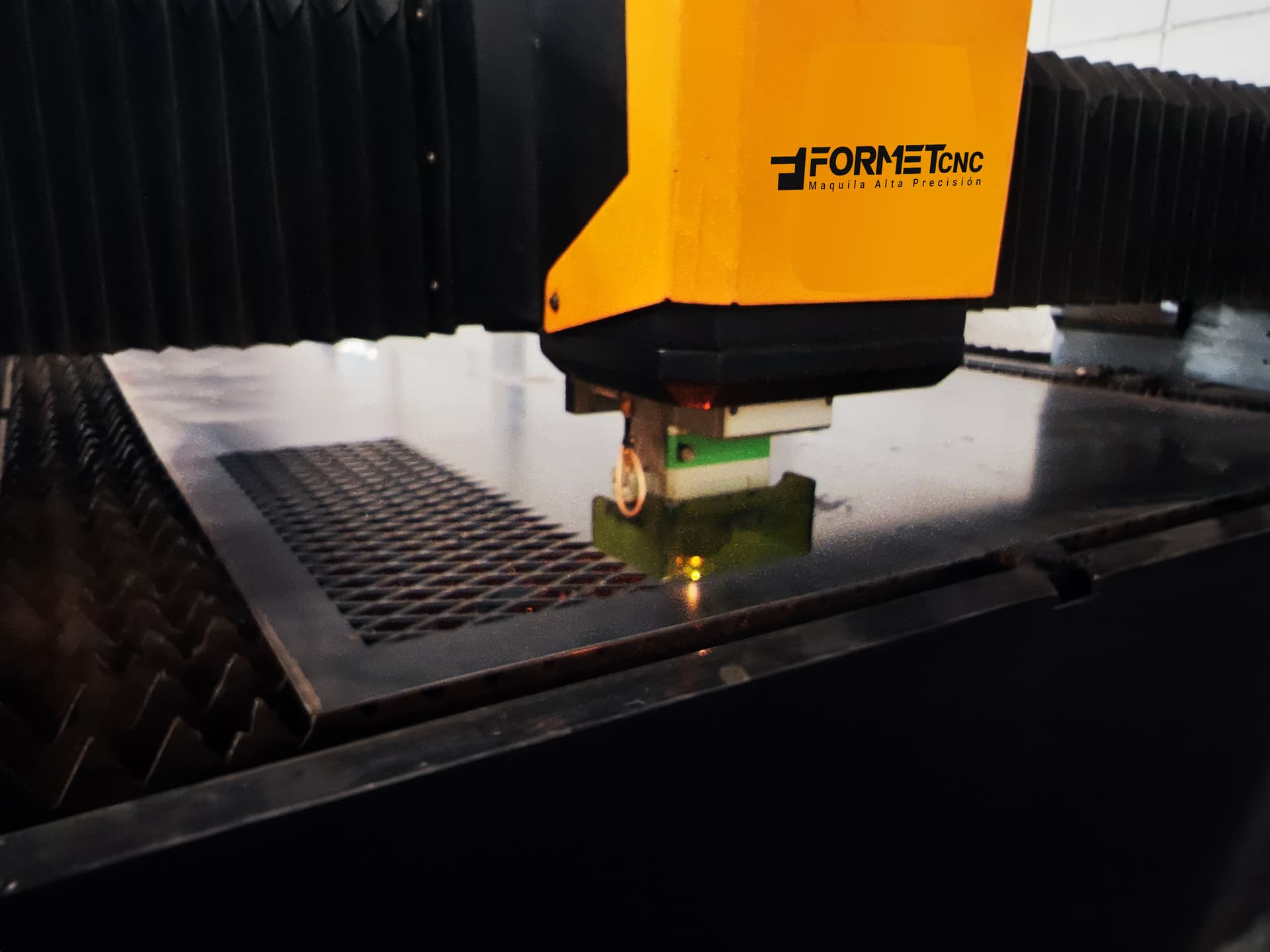 Máquina de corte láser realizando cortes precisos en láminas metálicas, garantizando exactitud milimétrica para proyectos industriales.